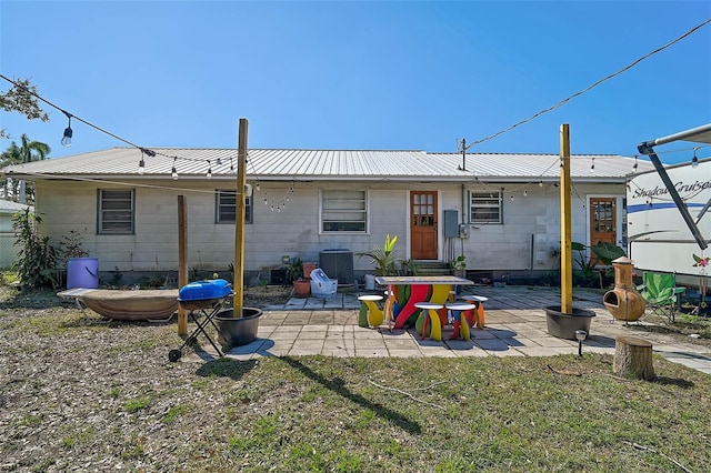 rear view of property featuring a patio area, metal roof, and central AC