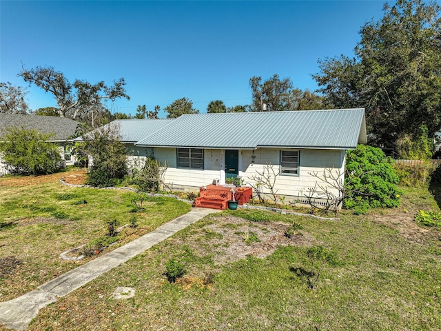 ranch-style home featuring a front yard and metal roof