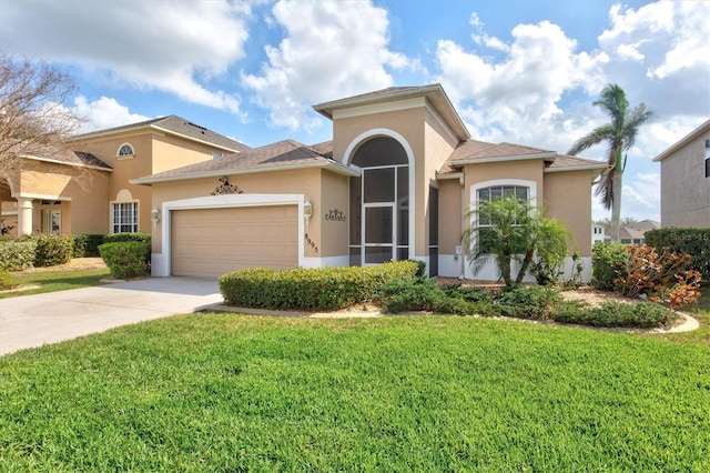 mediterranean / spanish-style house with a garage, driveway, a front lawn, and stucco siding