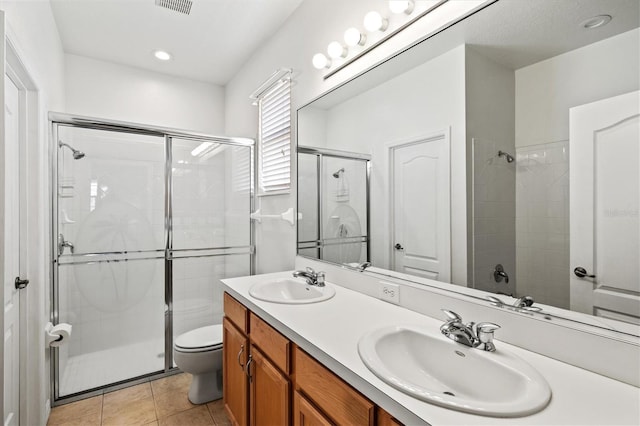 full bathroom featuring a stall shower, tile patterned flooring, a sink, and toilet