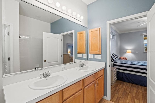 ensuite bathroom with double vanity, ornamental molding, a sink, and ensuite bathroom