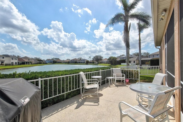 view of patio featuring a residential view, a water view, a grill, and a balcony