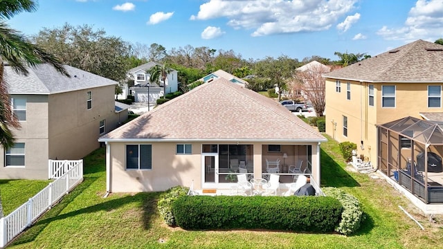 back of house featuring a shingled roof, a lawn, a sunroom, a residential view, and fence