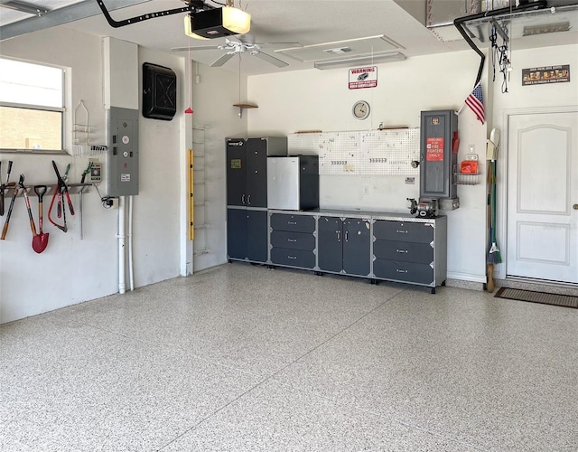 garage with ceiling fan, electric panel, and a garage door opener