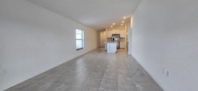 unfurnished living room featuring light tile patterned flooring and lofted ceiling