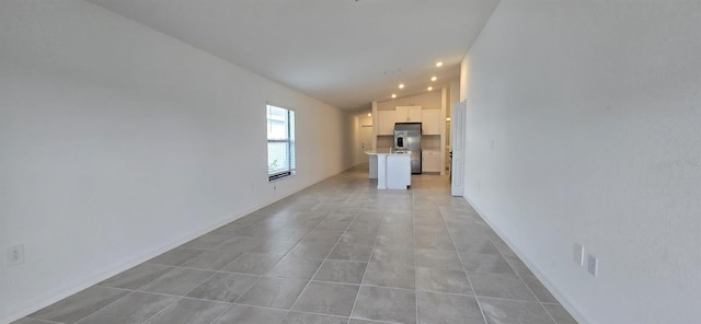 unfurnished living room featuring light tile patterned flooring and vaulted ceiling