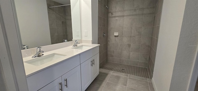 bathroom with vanity, tiled shower, and tile patterned floors