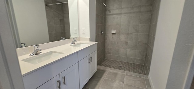 bathroom with tile patterned flooring, vanity, and a tile shower