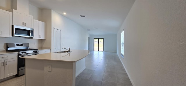 kitchen with appliances with stainless steel finishes, sink, an island with sink, and white cabinets