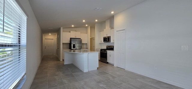 kitchen featuring sink, white cabinetry, stainless steel appliances, high vaulted ceiling, and an island with sink