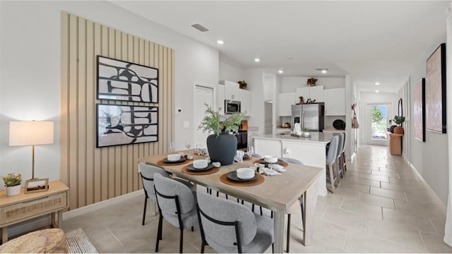 dining room featuring lofted ceiling and light tile patterned floors