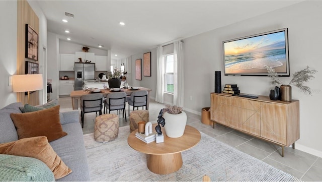 living room with light tile patterned floors and vaulted ceiling