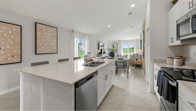 kitchen with a kitchen island with sink, sink, white cabinets, and appliances with stainless steel finishes