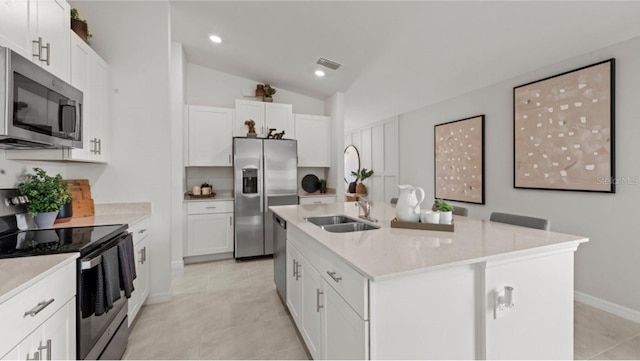 kitchen featuring sink, stainless steel appliances, white cabinets, and a center island with sink