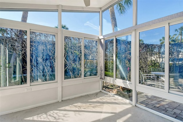 unfurnished sunroom with ceiling fan