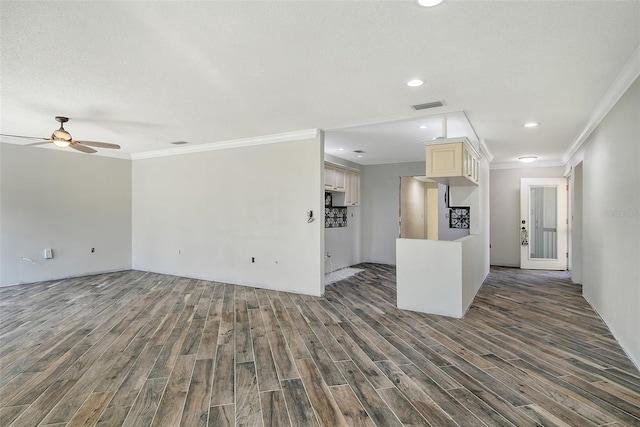 interior space with crown molding, a textured ceiling, visible vents, and wood finished floors