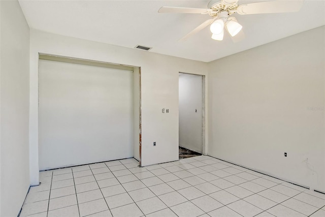 unfurnished bedroom featuring a ceiling fan, visible vents, a closet, and light tile patterned flooring