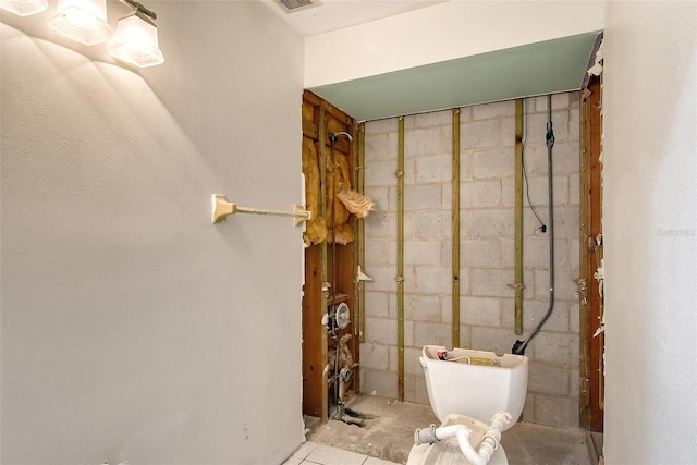 bathroom featuring concrete block wall