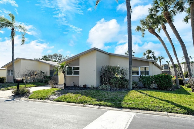 view of front of house featuring a front yard and stucco siding