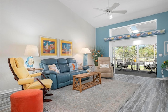 living room with hardwood / wood-style flooring, ceiling fan, and high vaulted ceiling