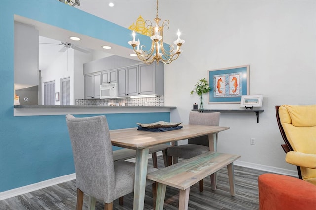 dining space featuring high vaulted ceiling, dark hardwood / wood-style floors, and ceiling fan with notable chandelier