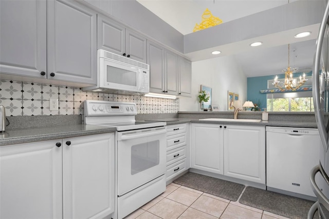 kitchen featuring sink, white cabinetry, light tile patterned floors, white appliances, and backsplash