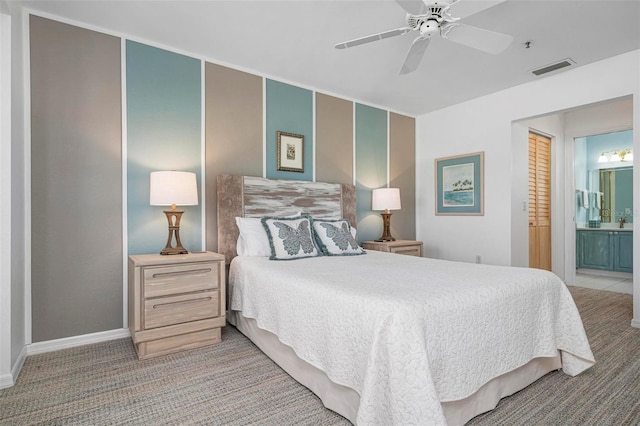 bedroom featuring ensuite bathroom, light carpet, and ceiling fan