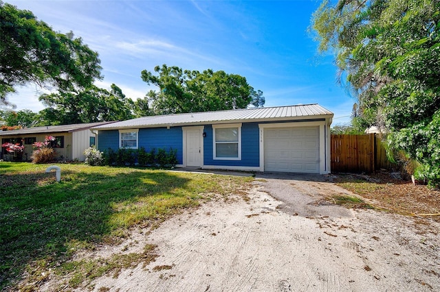 ranch-style house featuring a garage and a front lawn