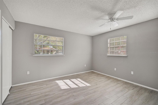 spare room featuring ceiling fan, light hardwood / wood-style flooring, and a textured ceiling