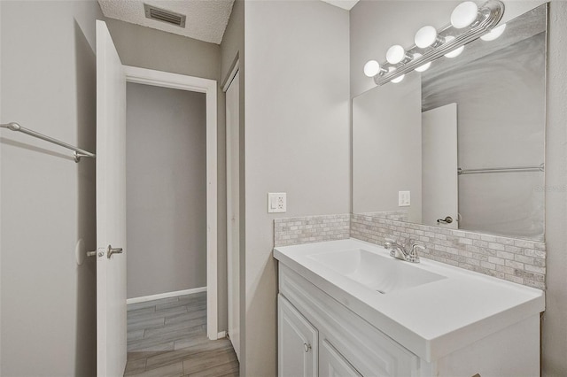 bathroom featuring vanity, hardwood / wood-style floors, and decorative backsplash