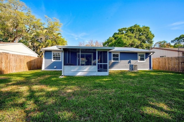 rear view of house with a sunroom, a yard, and cooling unit