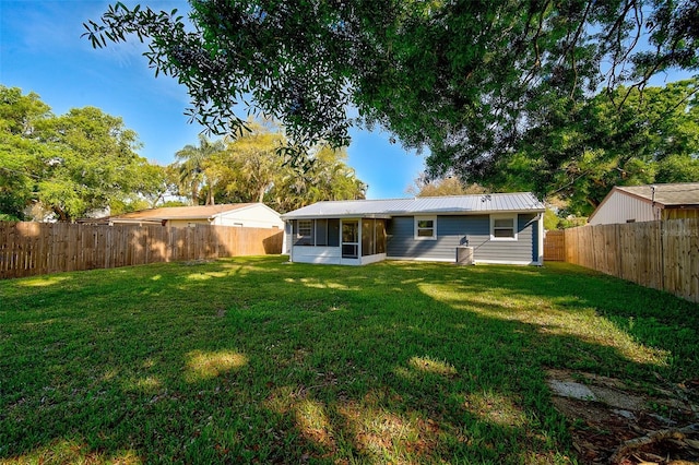 back of property featuring a yard and a sunroom