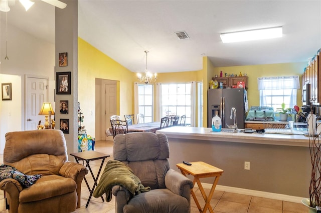 kitchen featuring lofted ceiling, sink, light tile patterned floors, a notable chandelier, and stainless steel appliances