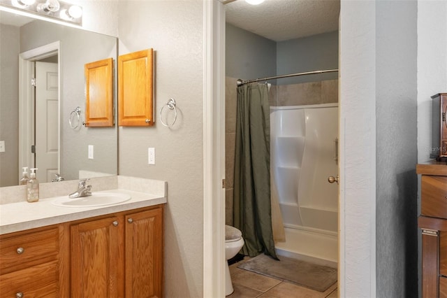 bathroom with curtained shower, vanity, toilet, tile patterned floors, and a textured ceiling