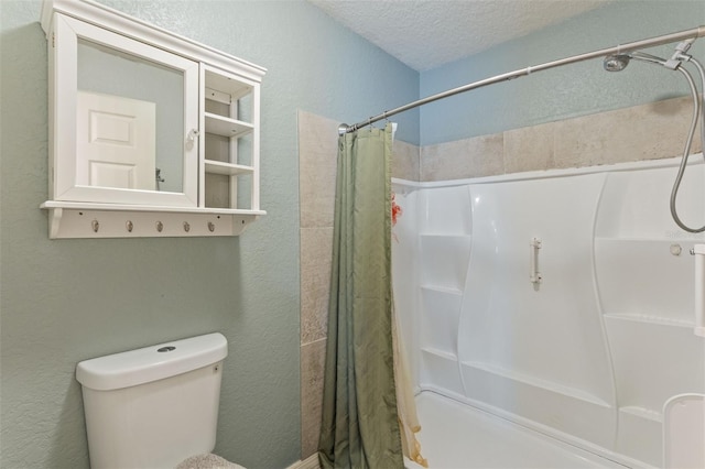 bathroom featuring a shower with curtain, toilet, and a textured ceiling