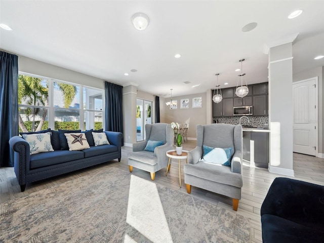 living room featuring an inviting chandelier and light wood-type flooring