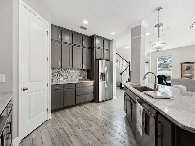 kitchen featuring sink, stainless steel fridge, tasteful backsplash, wine cooler, and decorative light fixtures