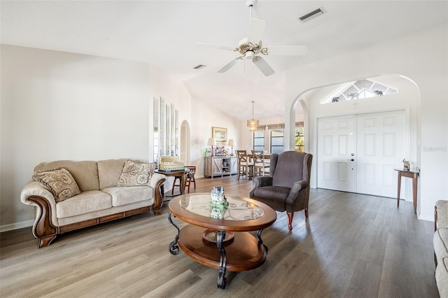 living room featuring vaulted ceiling, wood-type flooring, and ceiling fan