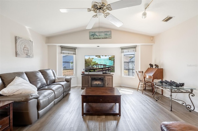 living room with lofted ceiling, light hardwood / wood-style floors, rail lighting, and ceiling fan