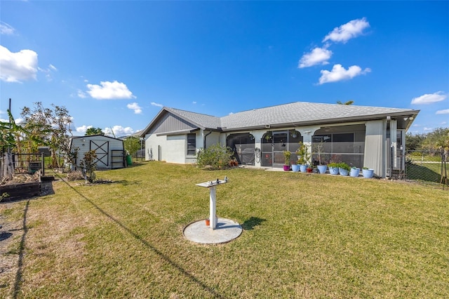 rear view of property with a storage unit, a sunroom, and a lawn