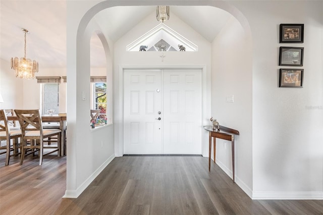 foyer featuring lofted ceiling, dark hardwood / wood-style floors, and an inviting chandelier