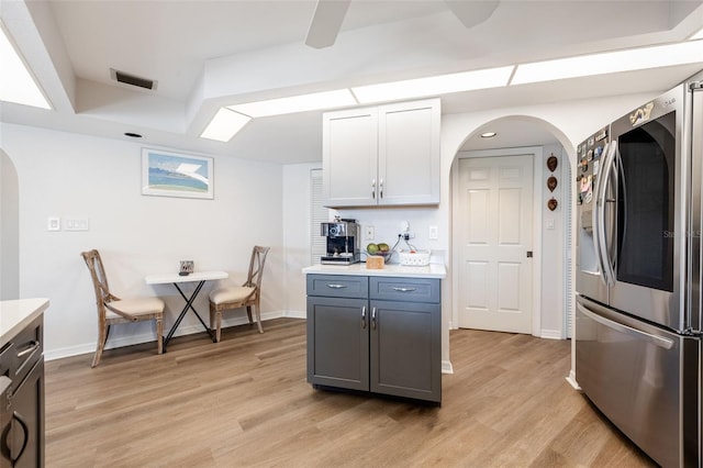 kitchen featuring gray cabinetry, stainless steel fridge, light hardwood / wood-style flooring, and white cabinets