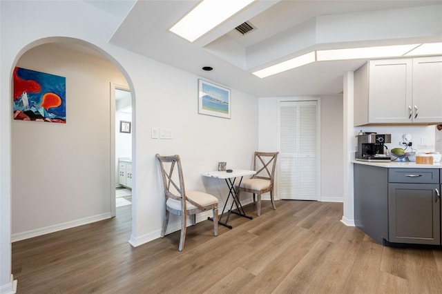 kitchen with white cabinetry, gray cabinets, and light wood-type flooring