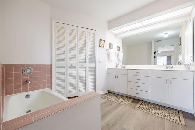 bathroom featuring hardwood / wood-style flooring, vanity, and a tub