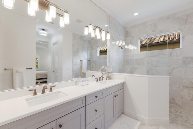 bathroom featuring tiled shower, vanity, and ornamental molding