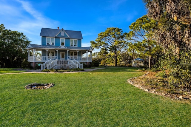 view of front facade featuring a porch, an outdoor fire pit, and a front lawn