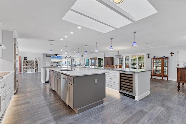 kitchen with a large island, sink, white cabinetry, hanging light fixtures, and stainless steel dishwasher