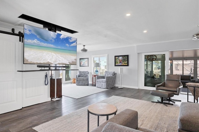 living room with a barn door and dark hardwood / wood-style flooring