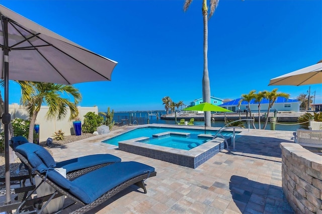 view of pool with an in ground hot tub, a water view, and a patio