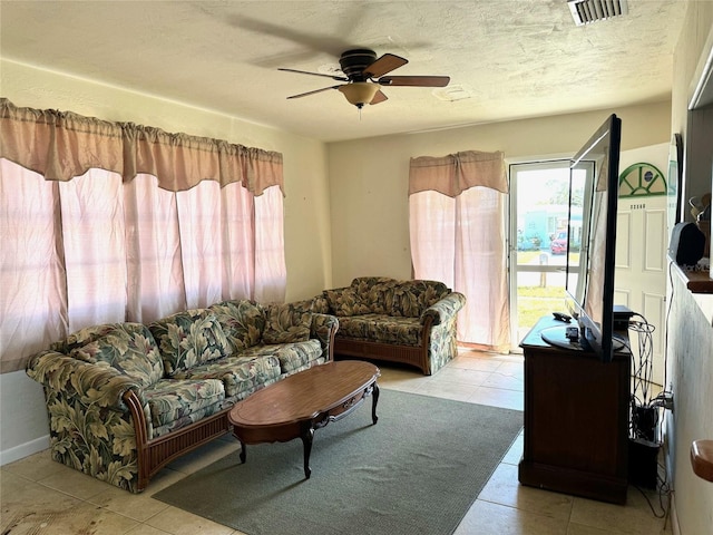 living room with light tile patterned flooring, ceiling fan, a textured ceiling, and a wealth of natural light